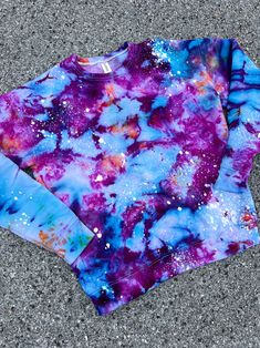 a purple and blue tie dye shirt laying on the ground