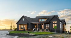 a black house sitting on top of a lush green field