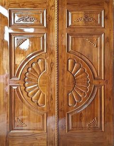 two wooden doors with intricate carvings on the front and side panels, one is made from wood