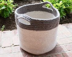 a crocheted basket sitting on top of a brick walkway