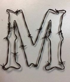 the letter m is made up of barbed wire