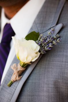 a boutonniere with a white rose on it is being used as a boutonniere