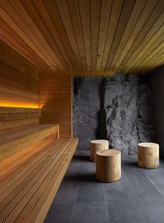 two wooden benches sitting next to each other on top of a stone floored area