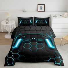 a bed covered in black and blue comforters with neon lights on the headboard