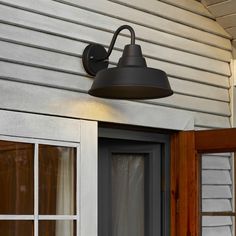 an outdoor light mounted on the side of a house next to a door and window