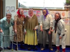 group of people standing in front of a classroom wall with crutches and canes