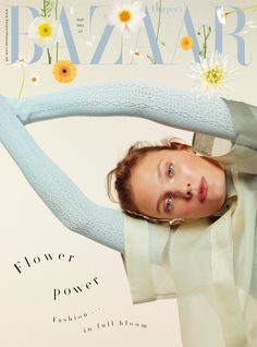 a woman is posing on the cover of bazaar magazine, with flowers in her hair