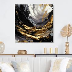 a living room with white couches and gold accents on the wall, along with black and white artwork