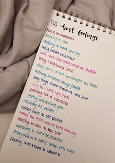 a notepad with the words best feelings written on it next to a gray blanket