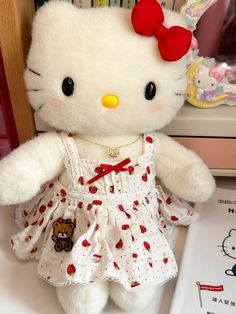 a white hello kitty stuffed animal sitting on top of a table