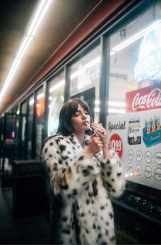 a woman standing in front of a coca cola machine