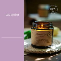 a candle sitting on top of a wooden table next to a bottle of lavender oil