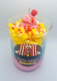 an ice cream sundae with gummy bears and candy corn on the top in a plastic cup