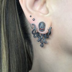 a woman wearing an octopus earring with red eyes