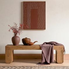 a wooden bench with a tea pot and vase on it in front of a painting