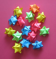 many origami bows are arranged on a pink surface