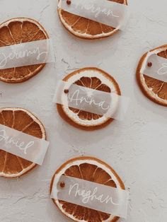 orange slices with name tags on them sitting on a white table top next to each other