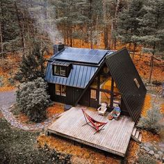 an aerial view of a small cabin in the woods