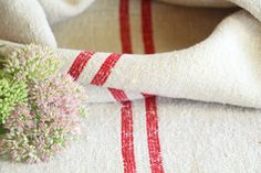 a bouquet of flowers sitting on top of a white towel next to a red and white striped pillow