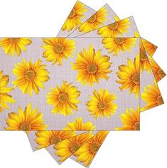 four yellow sunflowers on white placemats