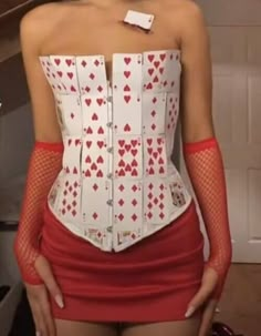 a woman in red skirt and white corset with playing cards on her back