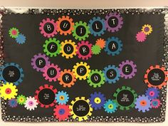 a bulletin board with colorful gears and words written in black on the front, along with white dots