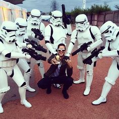 a man poses for a photo with stormtroopers in front of the camera