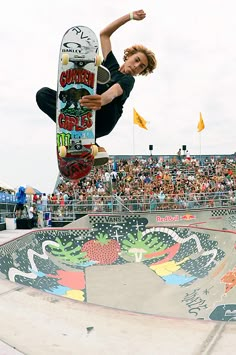 a man flying through the air while riding a skateboard in front of a crowd