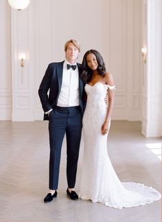 a man in a tuxedo and woman in a wedding dress pose for a photo