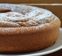 a cake with powdered sugar on top sitting on a plate