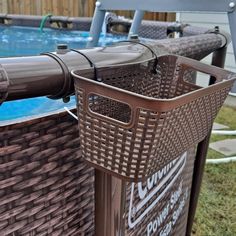 a brown wicker basket next to a swimming pool with the lid down on it