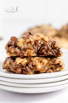 two chocolate chip cookies stacked on top of each other in front of a white plate