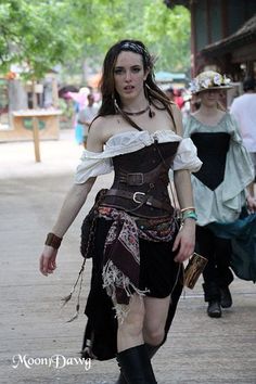 a woman dressed in steampunk clothing walking down the street with other people behind her