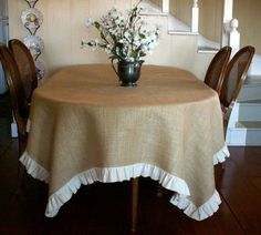 a vase with flowers on top of a table in front of some chairs and stairs