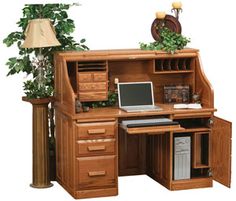 a wooden desk with a computer on top of it next to a potted plant