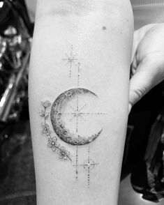 a black and white photo of a half moon tattoo