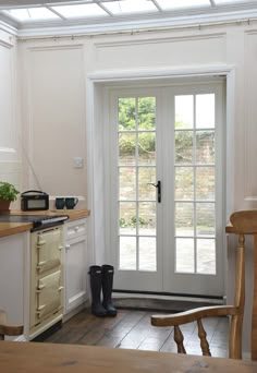 a kitchen with an open door and two chairs