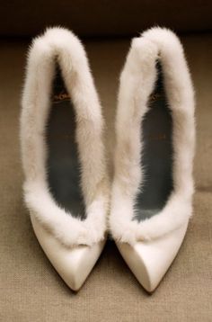 a pair of white shoes with fur on them