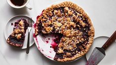 a piece of pie on a plate next to a fork and cup of coffee with spoons