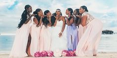 a group of women standing next to each other on a beach