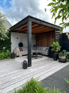 an outdoor living area with patio furniture and potted plants on the deck, surrounded by greenery