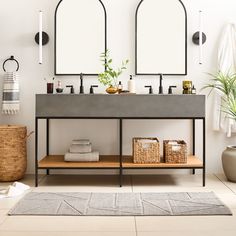 a bathroom with two sinks and mirrors on the wall next to a rug in front of it