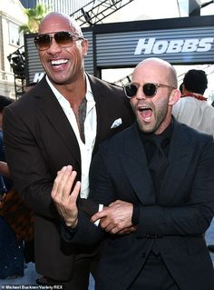 two men in suits and sunglasses standing next to each other