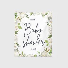 a baby shower sign with white flowers and greenery on the bottom that says, megan's baby shower