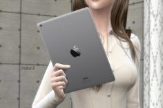 a woman holding an apple ipad in her right hand and pointing to the screen on her left