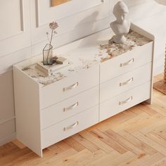 a white dresser with two drawers and a vase on top