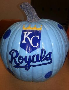 a kansas royals pumpkin sitting on top of a table with the kc logo painted on it