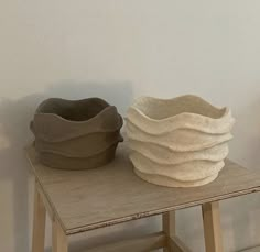 two clay bowls sitting on top of a wooden table