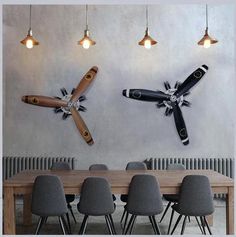 a dining room table and chairs in front of a wall mounted propeller plane on the wall