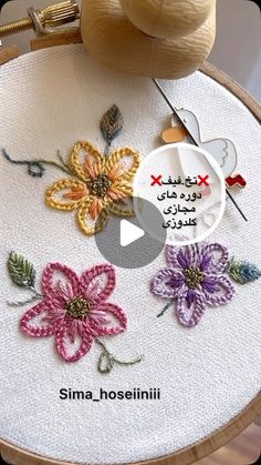 the embroidery is being worked on by someone using scissors and yarns to make flowers